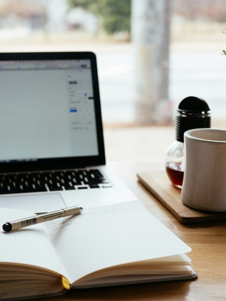 Arbeitsplatz mit Laptop und Notizbuch